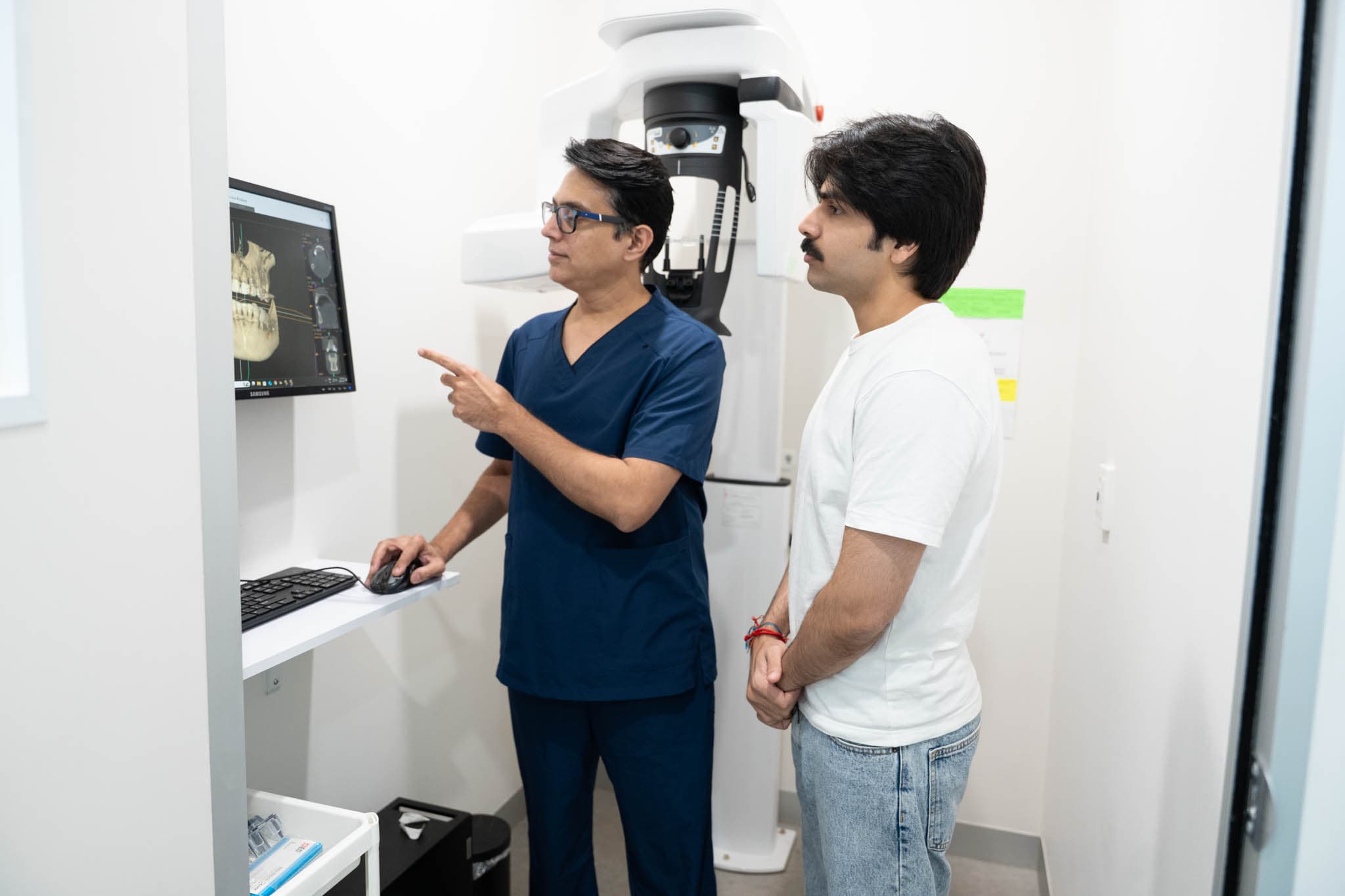 Warner dentist showing dental X-ray to patient at Exquisite Smiles