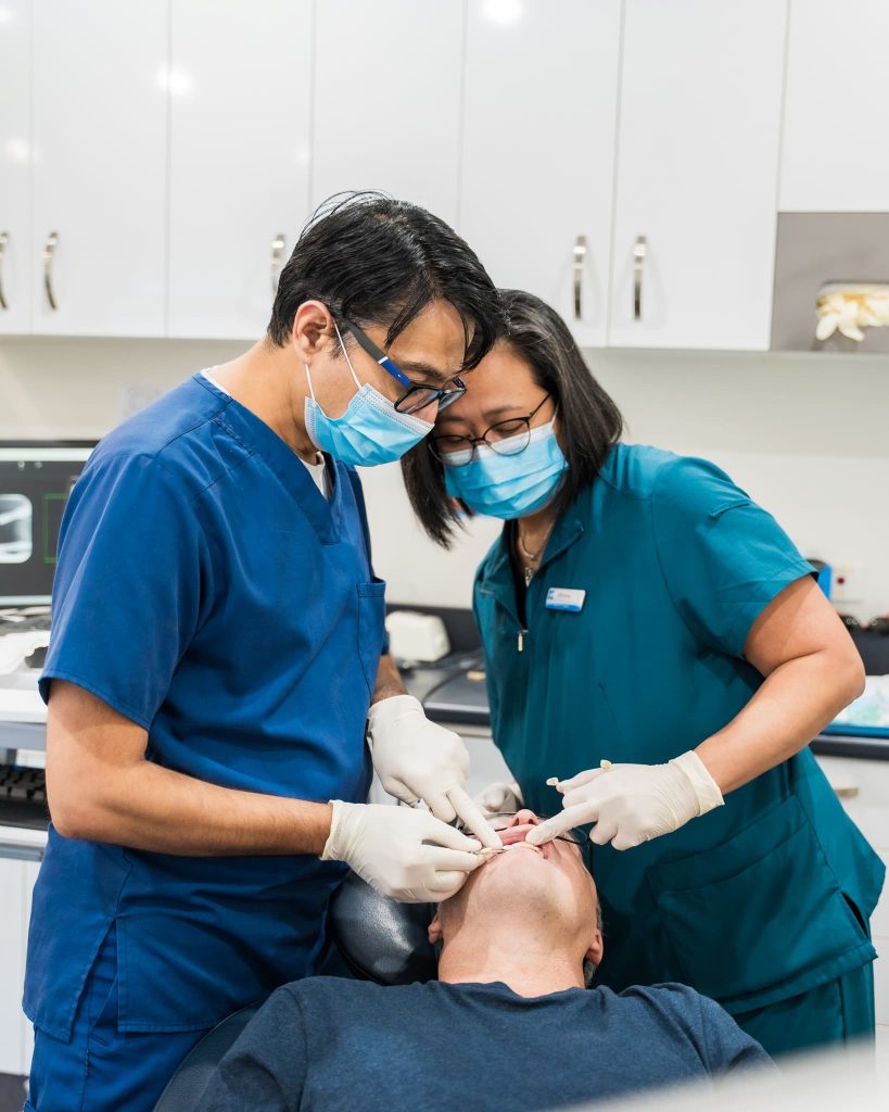 Warner dentist performing general dental procedure with assistant at Exquisite Smiles