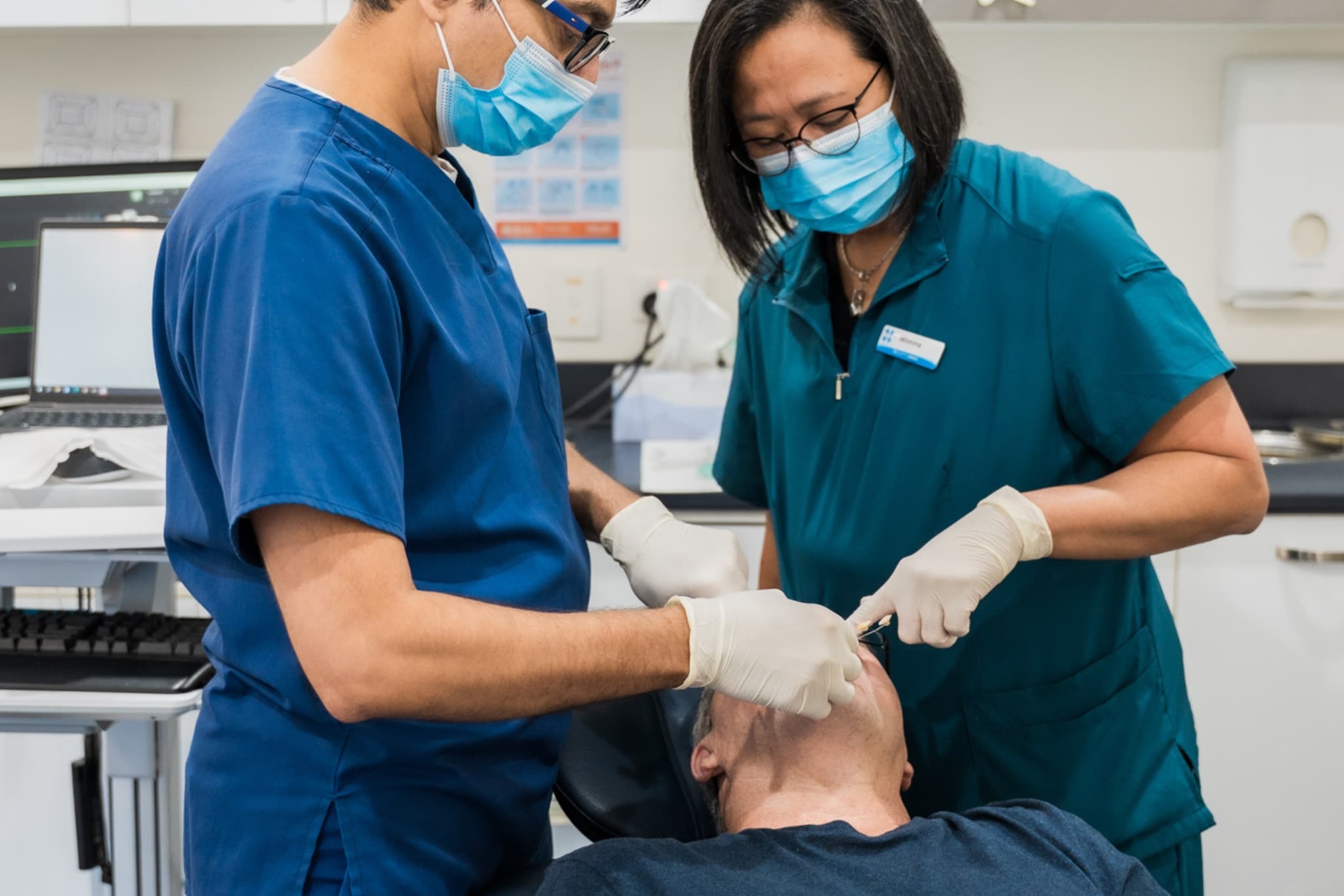 Dentists performing a tooth extraction procedure on a patient
