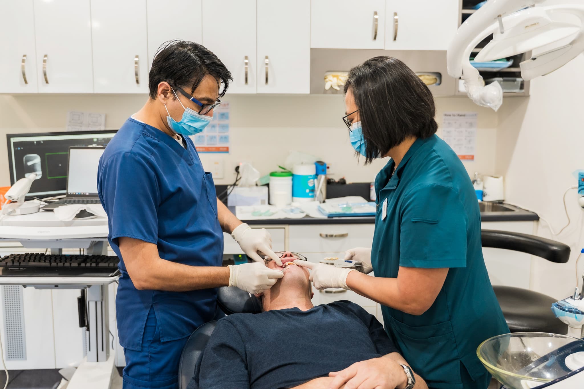 Dr Bhandare and assistant examining patient at Exquisite Smiles