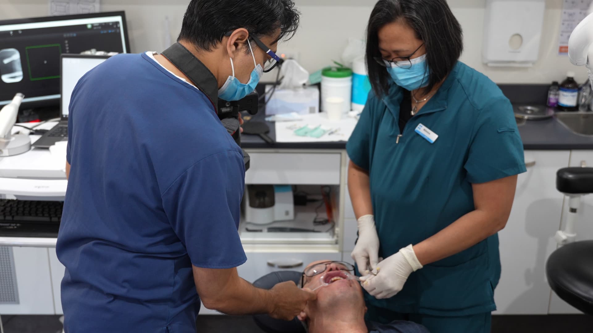 Dentist and dental assistant providing professional dental treatment at Exquisite Smiles clinic