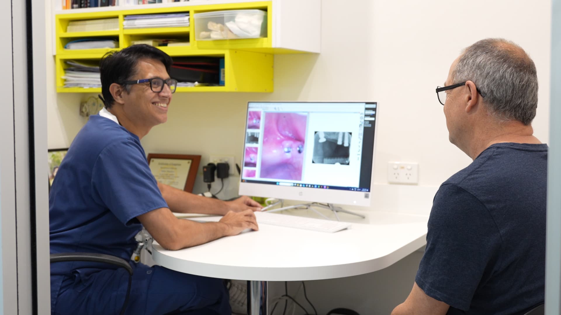 Dentist discussing SuperCare dental finance options with a patient during a consultation at Exquisite Smiles.