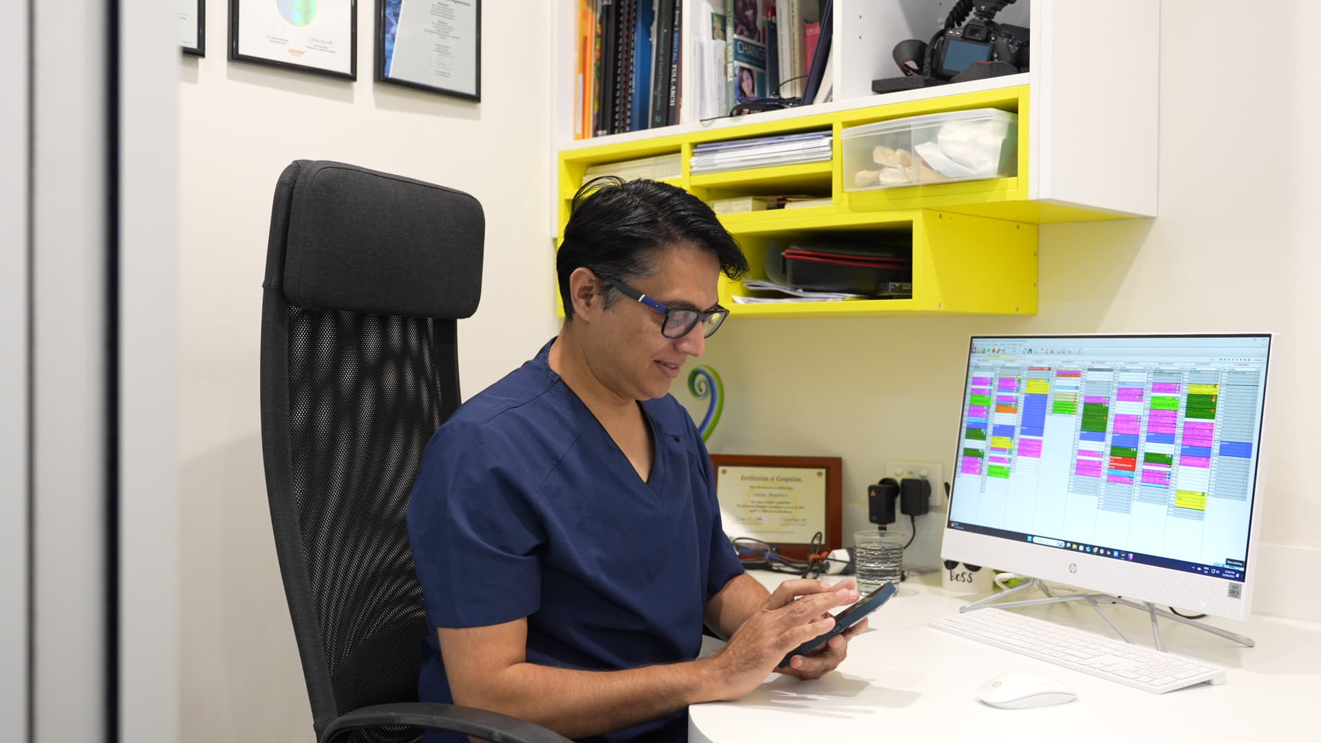 Dentist reviewing appointments in the clinic office after a patient enquiry at Exquisite Smiles.